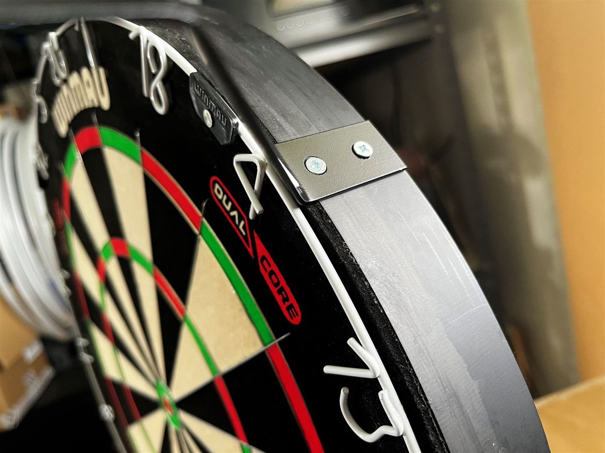 Close-up of a 3sixty aluminum bracket screwed to the dartboard mount
