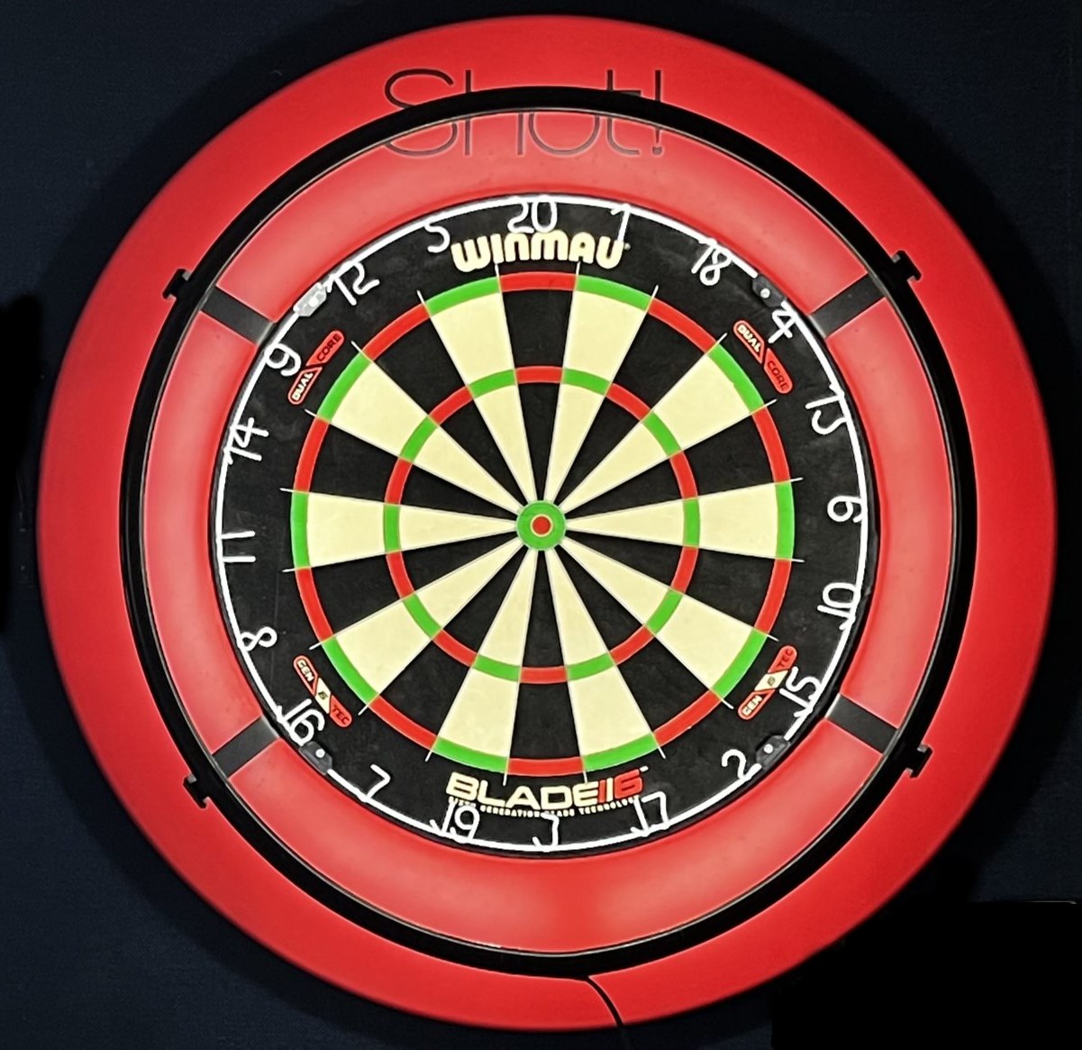 A dartboard mounted on a wall, evenly lit from behind by the 3sixty 360° light ring